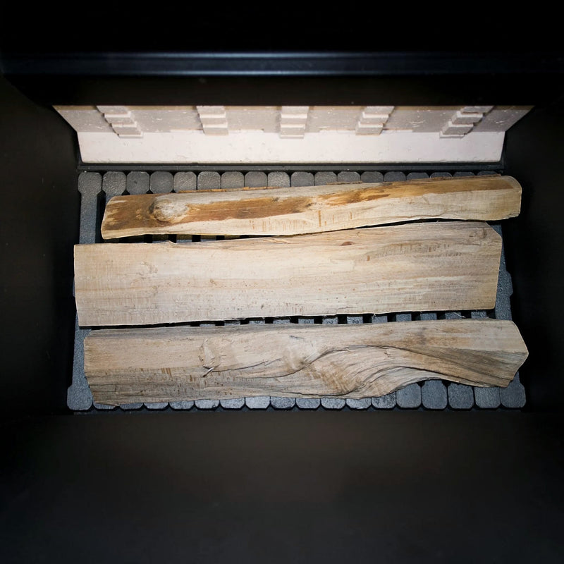 Blick in die 180 Liter Füllkammer des GEMA Shop Holzvergaserkessels ROJEK PK BIO 40 mit eingelegten Holzscheiten